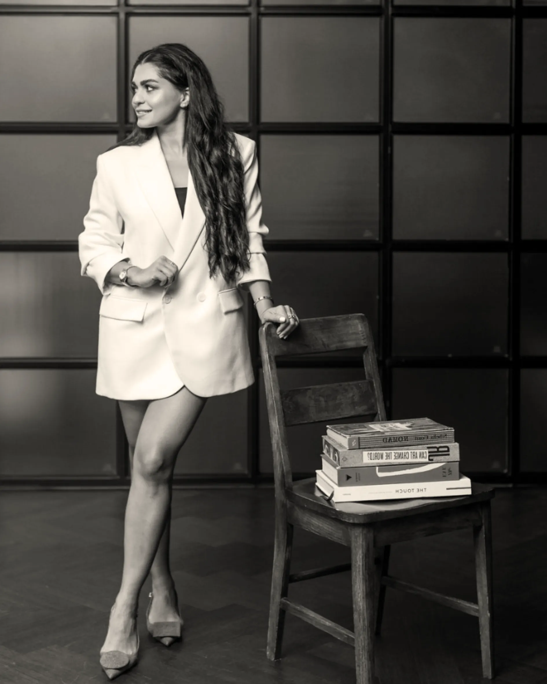 Mahsa Saeedi standing beside a stack of design books